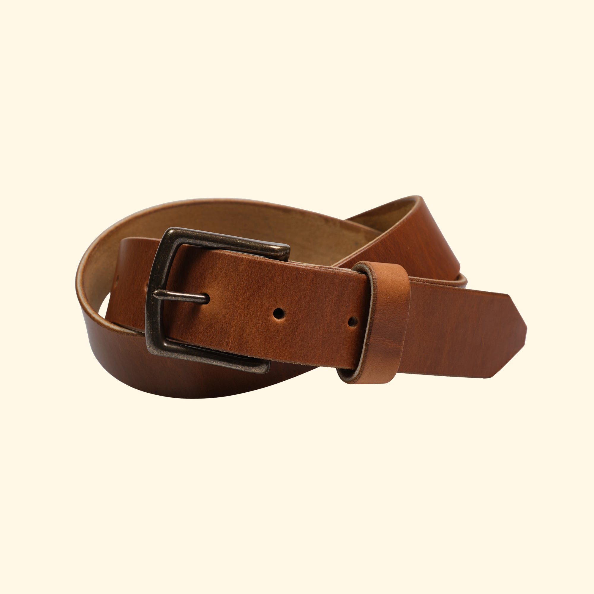 Handgefertigter Ledergürtel aus Horween Cavalier Leder in Sunflower, gezeigt mit einer antiken Metallschnalle. Vorderansicht des gerollten Gürtels.