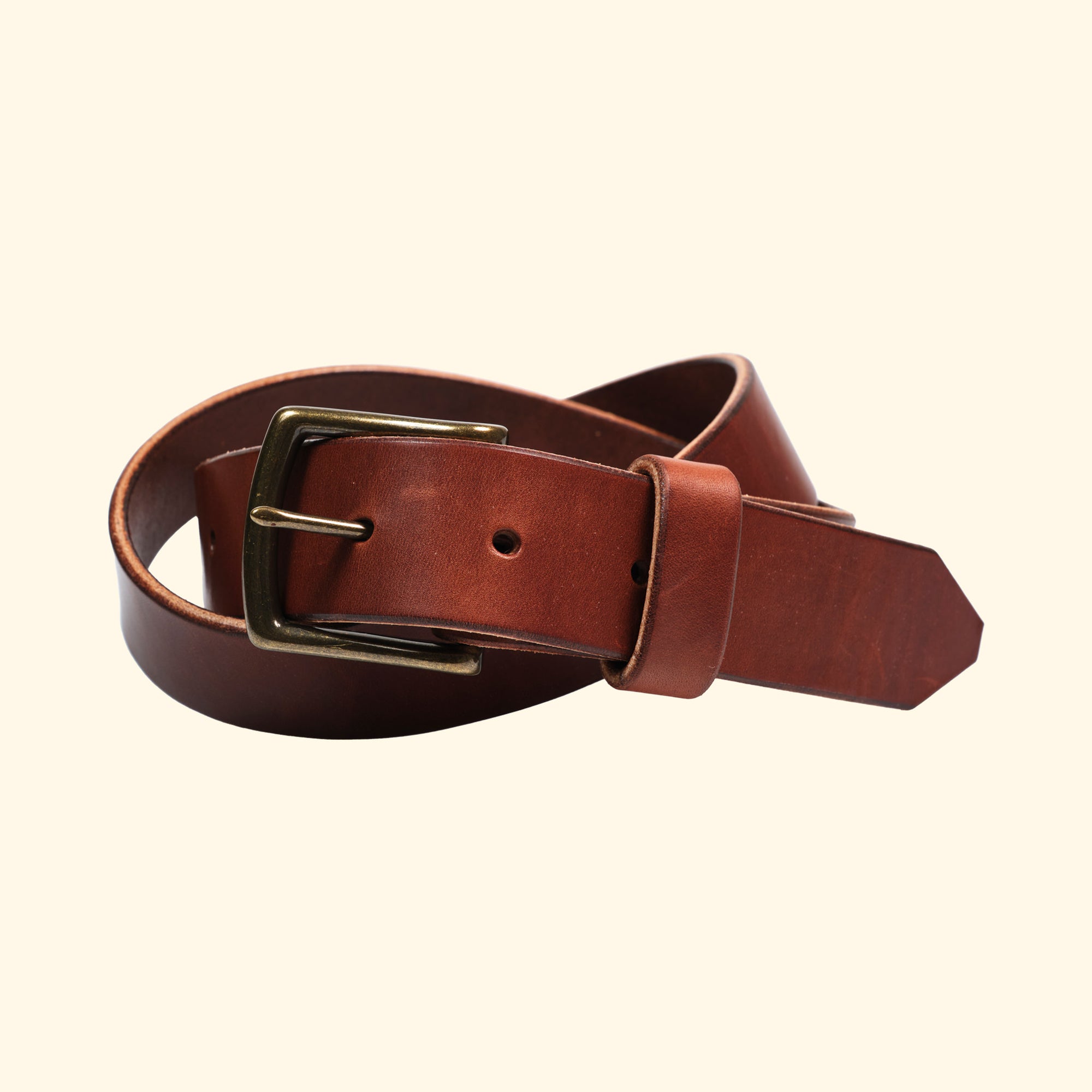 Handgefertigter Ledergürtel aus Wickett & Craig 'Traditional Harness' Leder in der Farbe Medium Brown, mit antiker Messingschnalle. Vorderansicht des gerollten Gürtels.